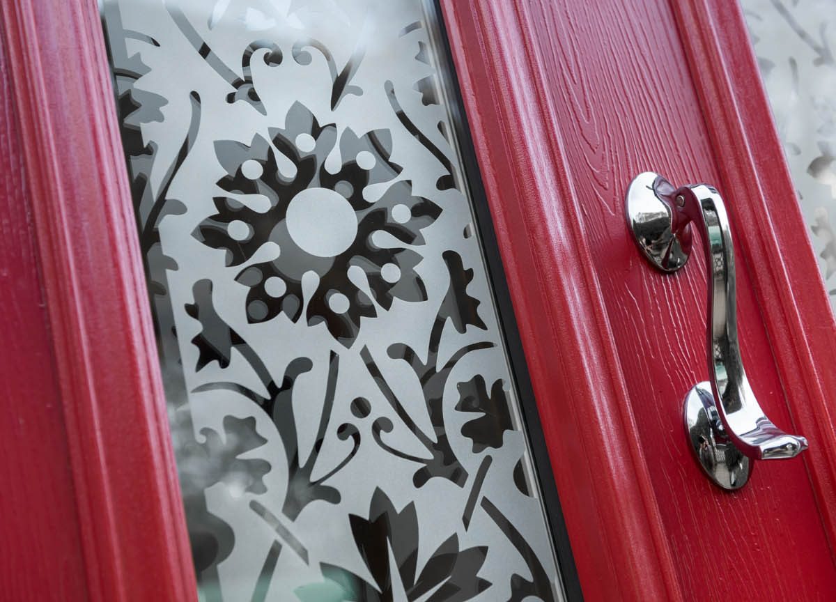 close up of a red composite door with elaborate glazing design