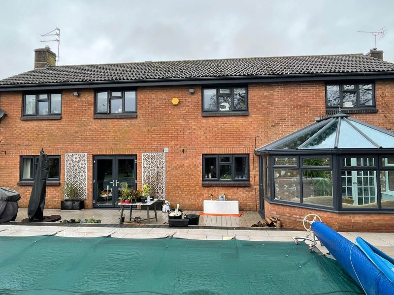 house with black windows and modern conservatory