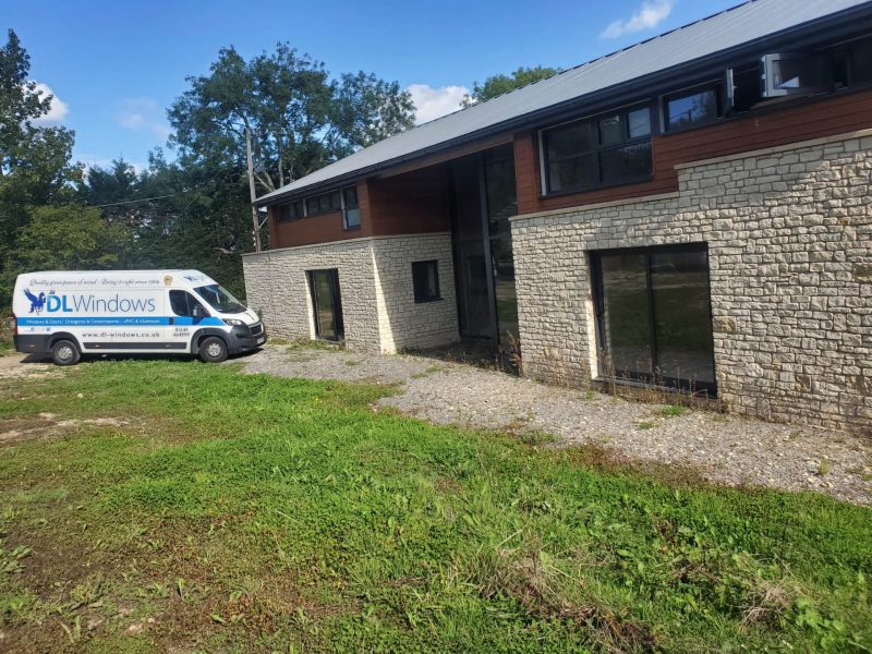 DL Windows van parked by a large house