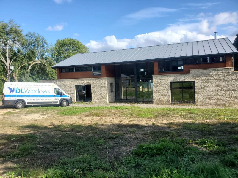 DL Windows van parked by a large house