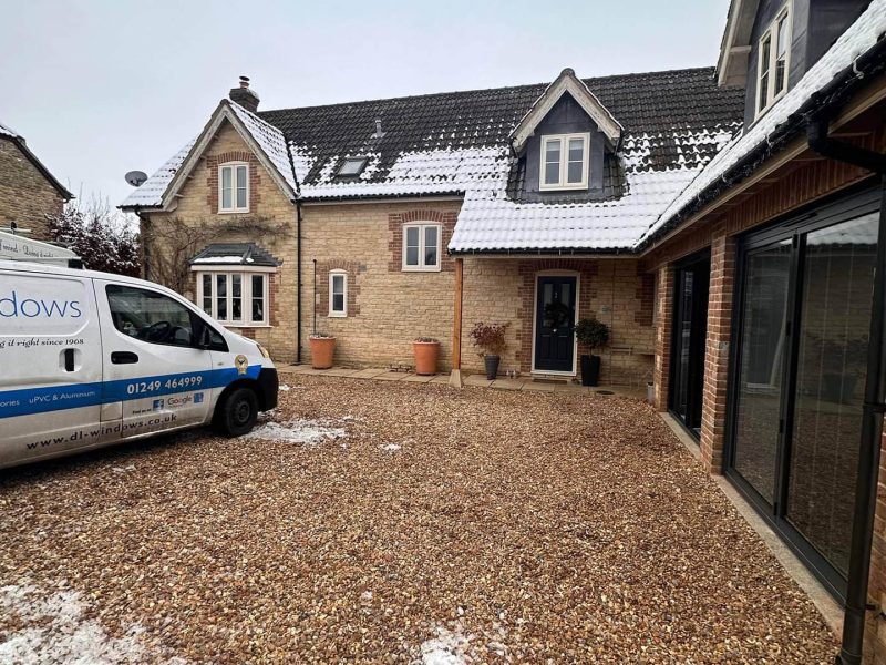 DL Windows van near a house with a light covering of snow